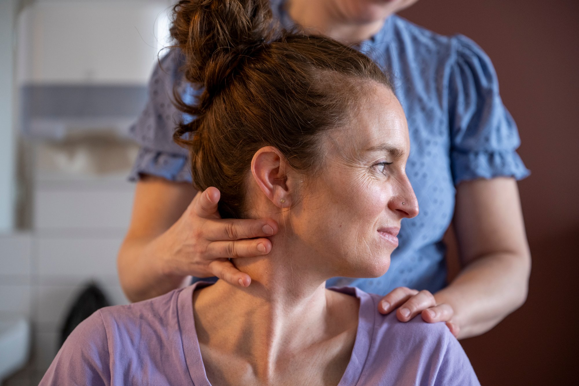 woman-giving-a-neck-massage-to-another-woman-indoo-2025-04-04-02-01-23-utc